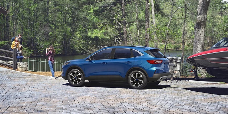 Blue Ford Escape parked near people preparing for adventure