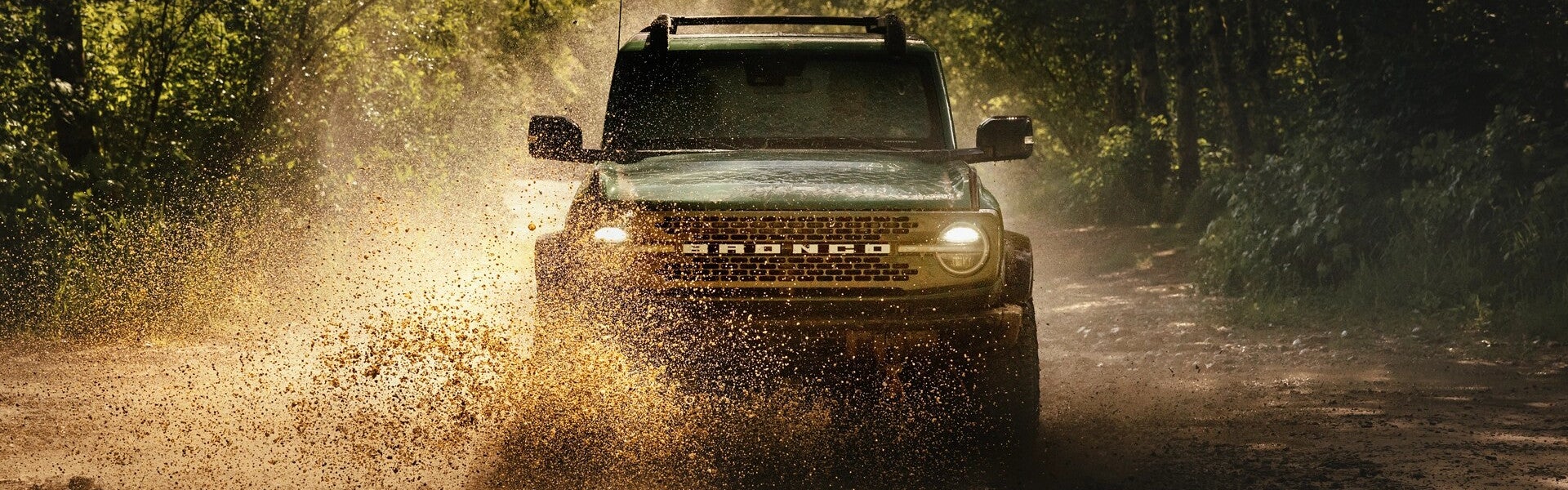2025 Ford Bronco driving through muddy terrain